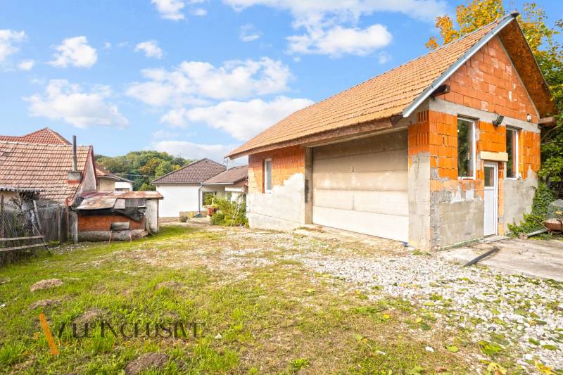 NA PREDAJ 5-IZBOVÝ RODINNÝ DOM NA 15Á POZEMKU,ŠALGOČKA - Rodinný dom v Šalgočke s nedokončenou garážou a drevenou kôlňou, trávnatý pozemok.