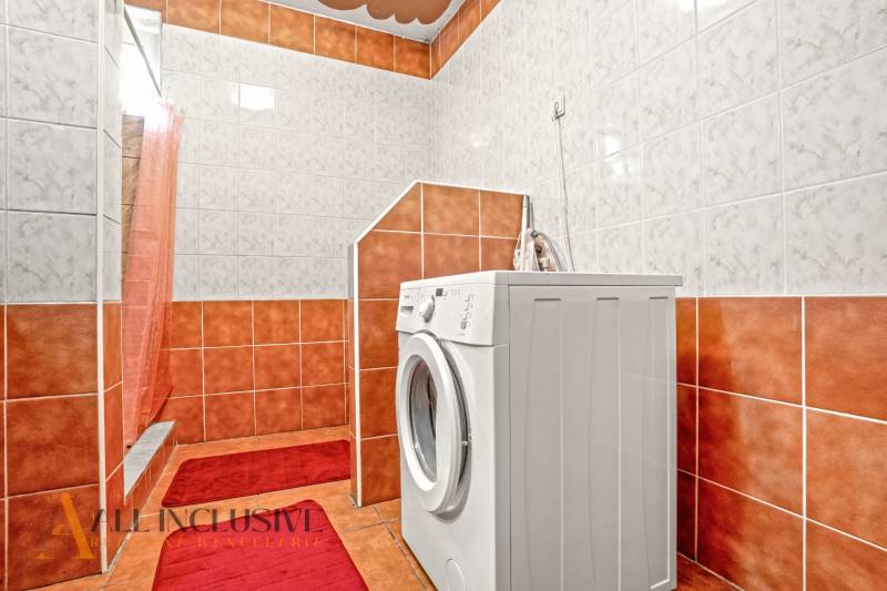 NA PREDAJ 5-IZBOVÝ RODINNÝ DOM NA 15Á POZEMKU,ŠALGOČKA - Kúpeľňa v rodinnom dome s práčkou, obložená oranžovými a bielymi kachličkami.