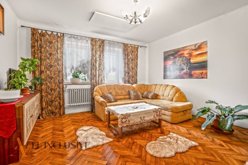 NA PREDAJ 5-IZBOVÝ RODINNÝ DOM NA 15Á POZEMKU,ŠALGOČKA - Obývacia izba s podlahou s dreveným dekorom, pohovkou a rastlinami v rodinnom dome.