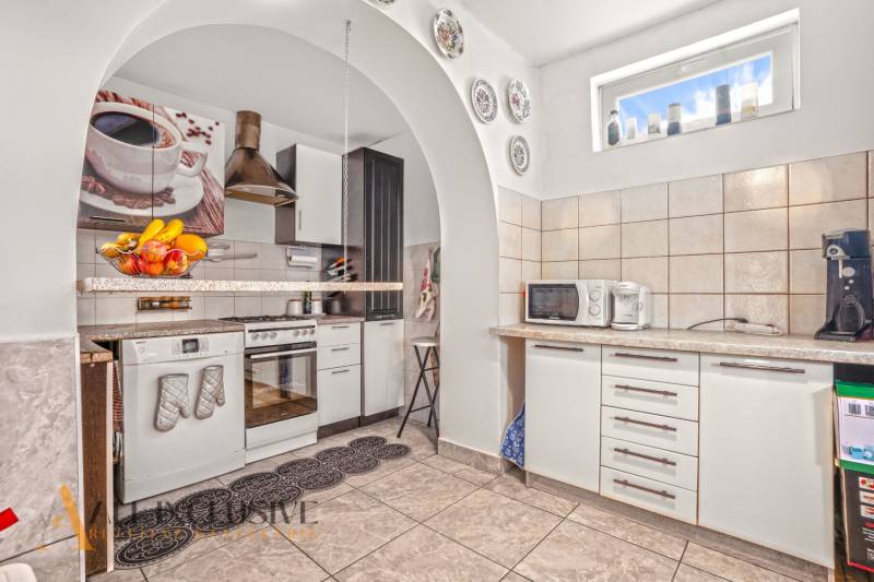 NA PREDAJ 5-IZBOVÝ RODINNÝ DOM NA 15Á POZEMKU,ŠALGOČKA - Kuchyňa v rodinnom dome s kachličkami, mikrovlnkou a spotrebičmi pod oblúkom.