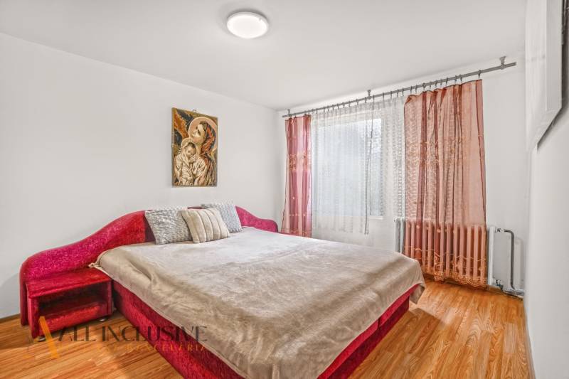 NA PREDAJ 5-IZBOVÝ RODINNÝ DOM NA 15Á POZEMKU,ŠALGOČKA - Spálňa s červenou posteľou, podlahou s dreveným dekorom a zaujímavým obrazom v rodinnom dome.