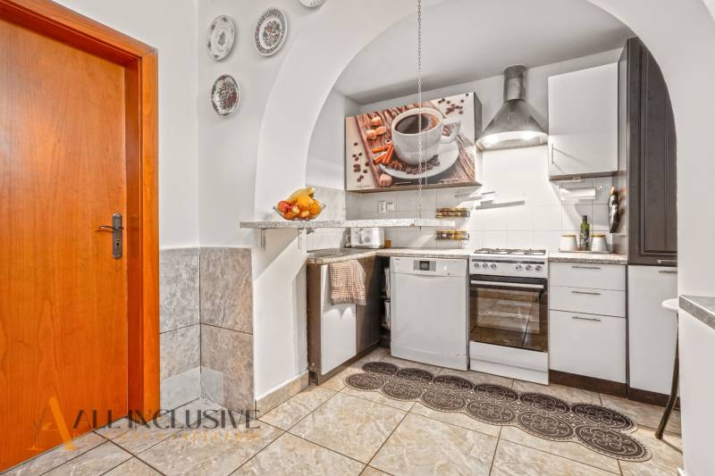 NA PREDAJ 5-IZBOVÝ RODINNÝ DOM NA 15Á POZEMKU,ŠALGOČKA - Kuchyňa so spotrebičmi, šálka kávy na obraze, dekoratívne taniere v rodinnom dome.