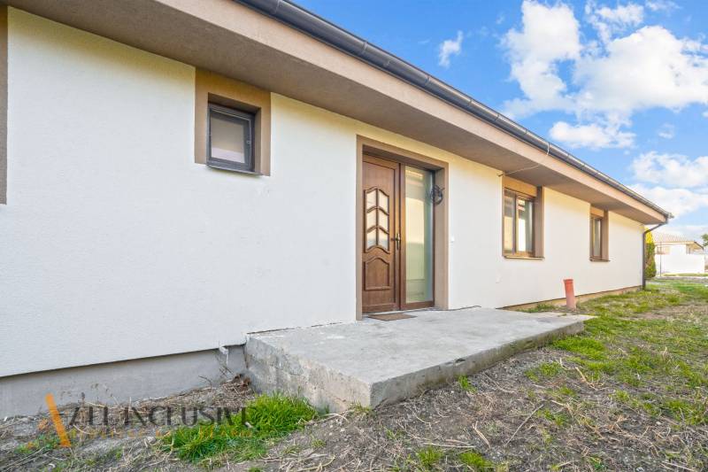 REZERVOVANÉ 5-IZBOVÝ RODINNÝ DOM VO VEĽKEJ PAKE - Rodinný dom vo Veľkej Pake s bielou fasádou a vchodovými dverami.