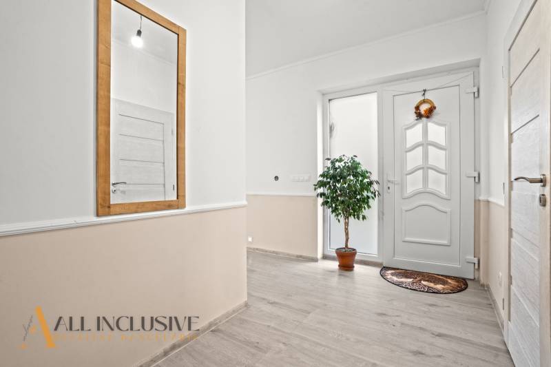 REZERVOVANÉ 5-IZBOVÝ RODINNÝ DOM VO VEĽKEJ PAKE - Chodba v rodinnom dome s bielymi dverami, zrkadlom a izbovou rastlinou.