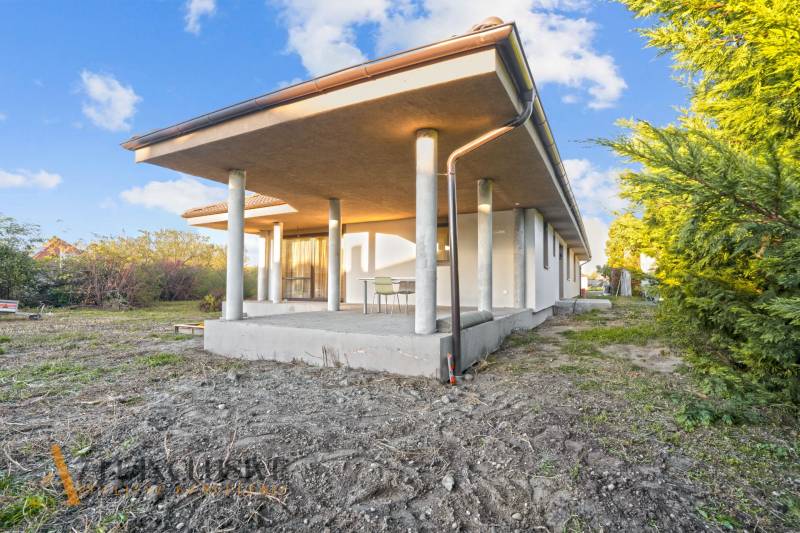 REZERVOVANÉ 5-IZBOVÝ RODINNÝ DOM VO VEĽKEJ PAKE - Rodinný dom vo Veľkej Pake s terasou, obklopený zeleňou a modrou oblohou.