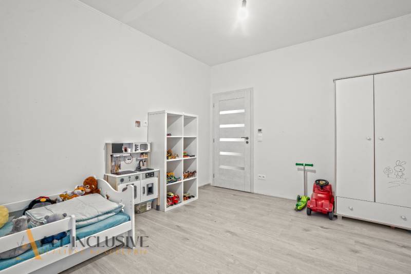 REZERVOVANÉ 5-IZBOVÝ RODINNÝ DOM VO VEĽKEJ PAKE - Detská izba v rodinnom dome s posteľou, hračkami a podlahou s dreveným dekorom.