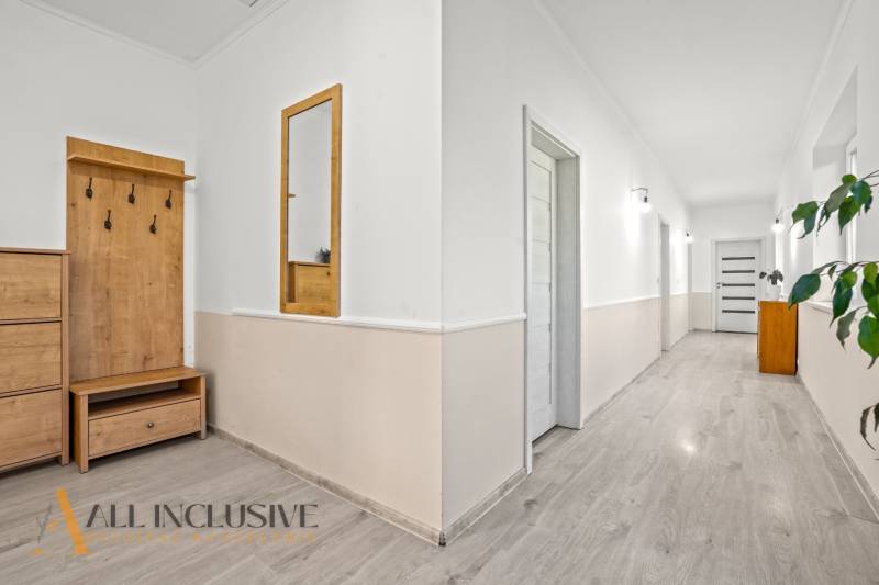 REZERVOVANÉ 5-IZBOVÝ RODINNÝ DOM VO VEĽKEJ PAKE - Chodba v rodinnom dome s bielymi stenami a dreveným dekórom.