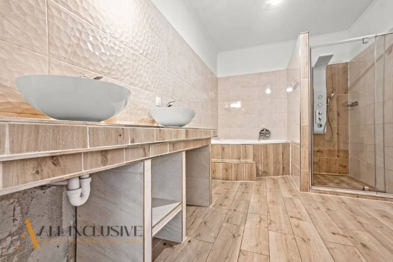 REZERVOVANÉ 5-IZBOVÝ RODINNÝ DOM VO VEĽKEJ PAKE - Kúpeľňa v rodinnom dome s vaňou, sprchovacím kútom a podlahou s dreveným dekorom.