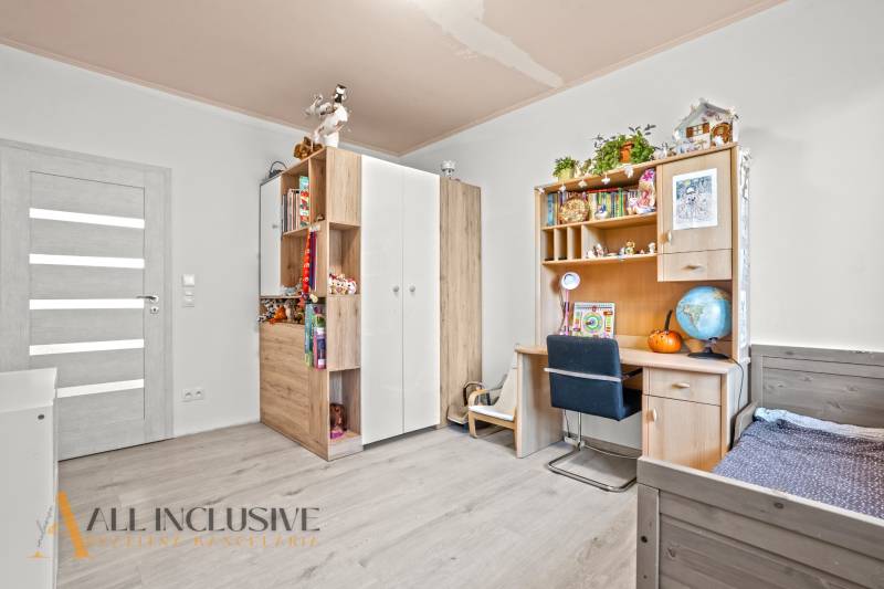 REZERVOVANÉ 5-IZBOVÝ RODINNÝ DOM VO VEĽKEJ PAKE - Detská izba v rodinnom dome s policami, písacím stolom a podlahou s dreveným dekorom.