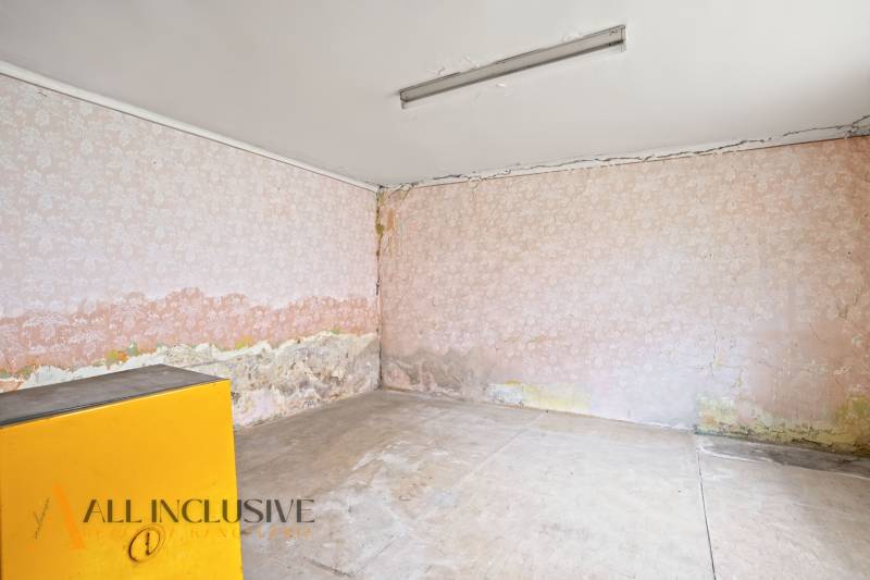 NA PREDAJ 4-IZBOVÝ RODINNÝ DOM V OBCI MOSTOVÁ - Izba v rodinnom dome s poškodenými stenami a starou tapetou.