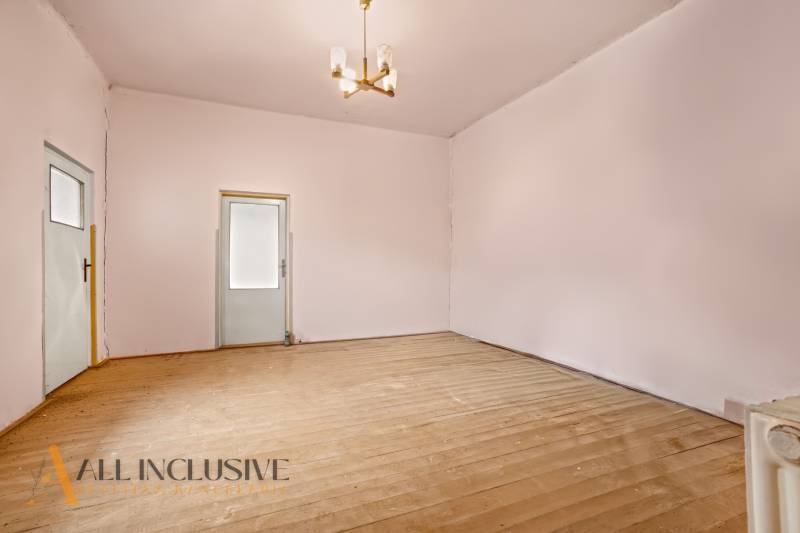 NA PREDAJ 4-IZBOVÝ RODINNÝ DOM V OBCI MOSTOVÁ - Priestranná miestnosť s podlahou s dreveným dekorom a dvomi dverami, rodinný dom.