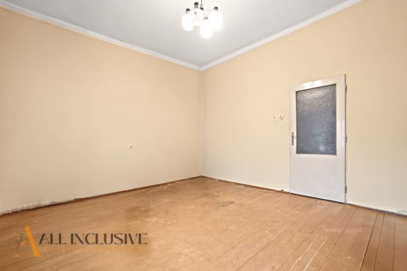 NA PREDAJ 4-IZBOVÝ RODINNÝ DOM V OBCI MOSTOVÁ - Izba v rodinnom dome s podlahou s dreveným dekorom a jednoduchým osvetlením.