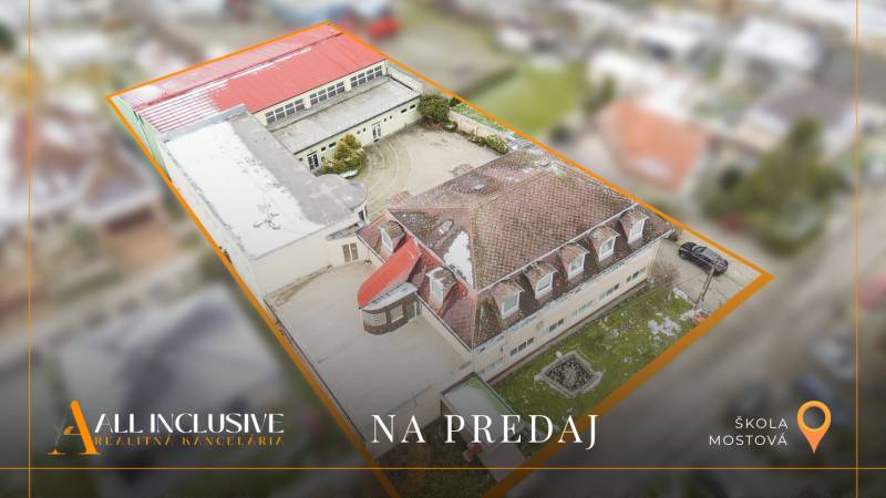 NA PREDAJ ŠKOLSKÁ BUDOVA NA VEĽKOM POZEMKU, MOSTOVÁ - Budova školy v Mostovej, zobrazená z vtáčej perspektívy, s vonkajšími priestormi.