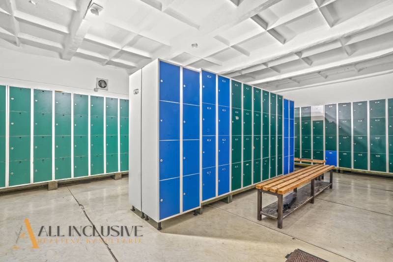 NA PREDAJ ŠKOLSKÁ BUDOVA NA VEĽKOM POZEMKU, MOSTOVÁ - Skrinky a lavičky v šatni budovy s betónovou podlahou.