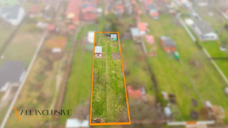 NA PREDAJ STAVEBNÝ POZEMOK (1046 m²), VEĽKÝ MEDER - Letecký pohľad na pozemok na bývanie vo Veľkom Mederi, s trávnatou plochou.