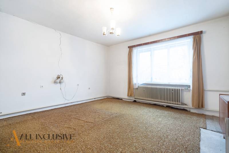 Na predaj 4-izbový rodinný dom, Gabčíkovo - Izba v rodinnom dome s kobercovou podlahou, s oknom a radiátorom.