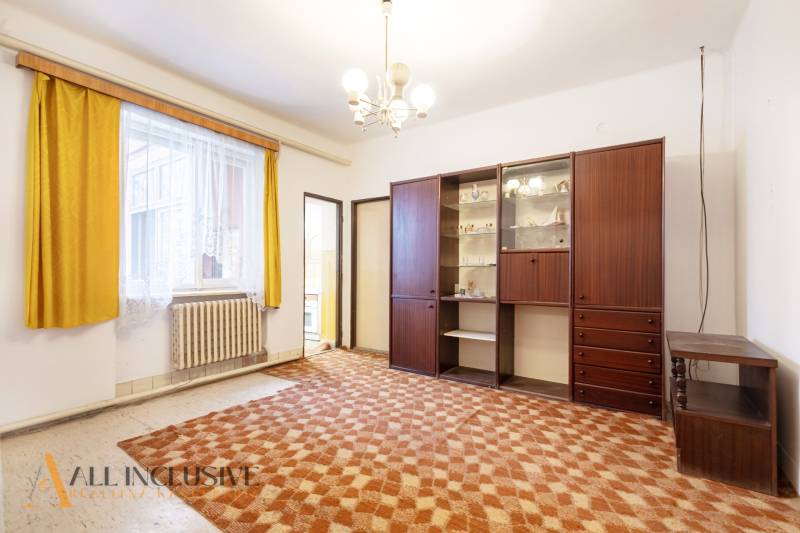 Na predaj 4-izbový rodinný dom, Gabčíkovo - Obývacia izba v rodinnom dome so žltými závesmi a retro skriňou.