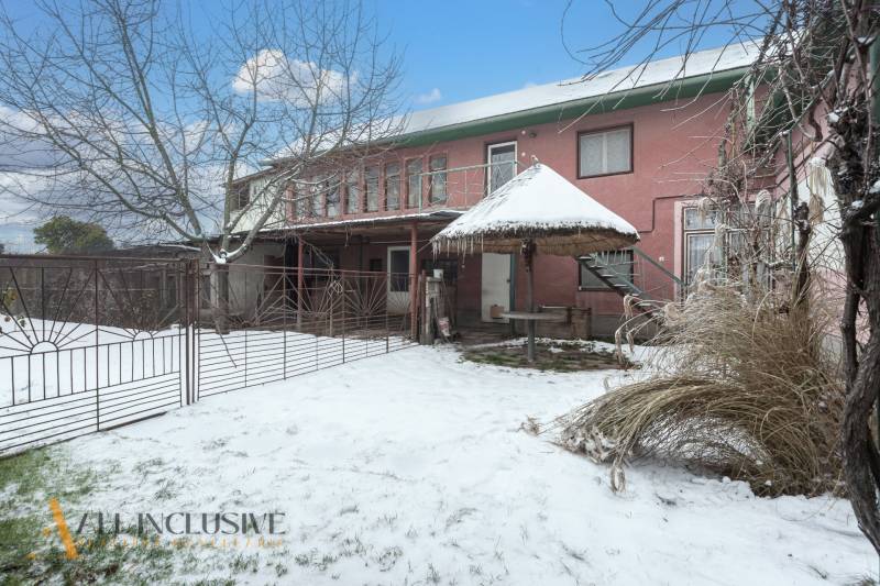 Na predaj 4-izbový rodinný dom, Gabčíkovo - Rodinný dom v Gabčíkove s vonkajším dvorom, stromom a snehovou pokrývkou.