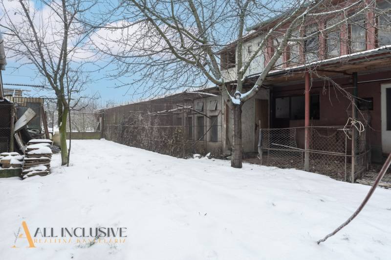 Na predaj 4-izbový rodinný dom, Gabčíkovo - Snehom pokrytý dvor rodinného domu v Gabčíkove s holými stromami a starou budovou.