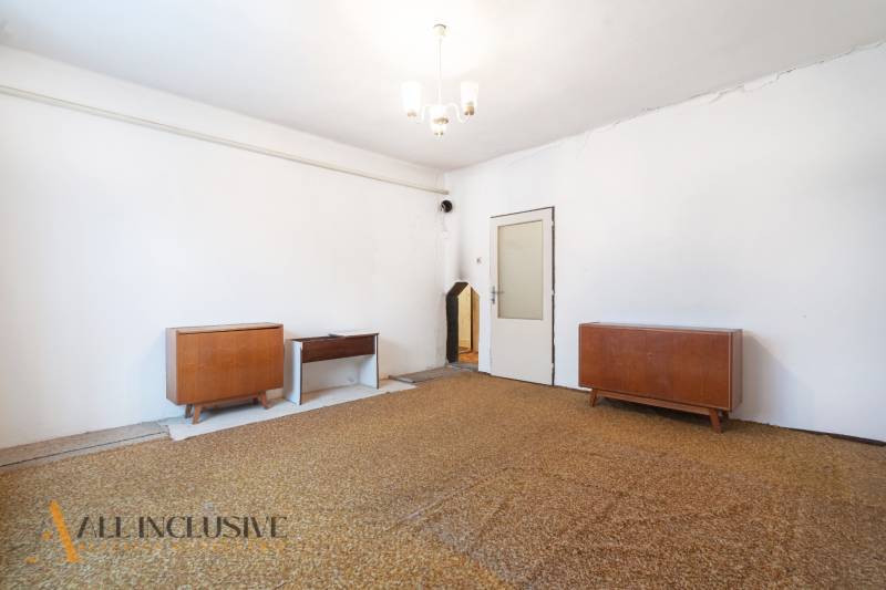 Na predaj 4-izbový rodinný dom, Gabčíkovo - Obývacia izba v rodinnom dome s nábytkom, bielymi stenami a závesným svietidlom.