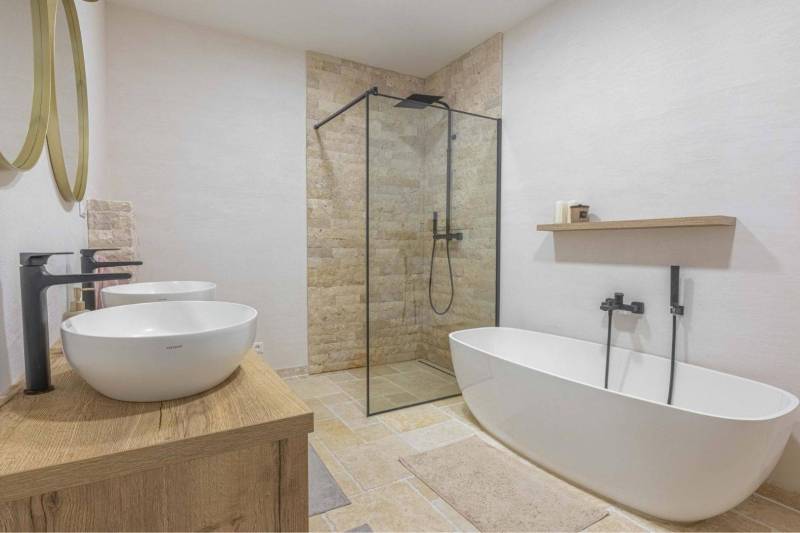 NA PREDAJ 4 IZB RD S DVOJGARÁŽOU, DUNAJSKÁ STREDA - Kúpeľňa v rodinnom dome s vaňou, sprchou a umývadlami na podlahe s dreveným dekorom.