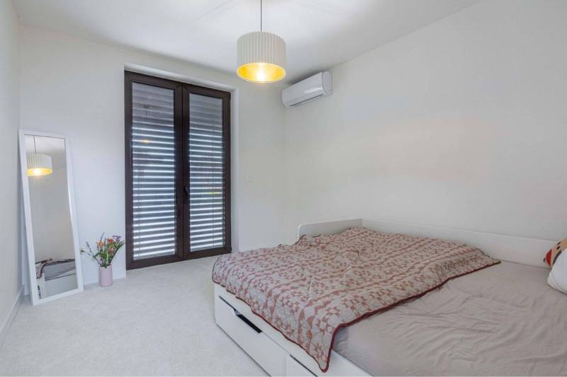 NA PREDAJ 4 IZB RD S DVOJGARÁŽOU, DUNAJSKÁ STREDA - Spálňa v rodinnom dome so zrkadlom, posteľou, klimatizáciou a francúzskym oknom.