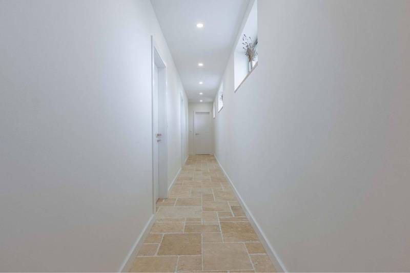 NA PREDAJ 4 IZB RD S DVOJGARÁŽOU, DUNAJSKÁ STREDA - Úzky svetlý chodba s bielymi stenami a kamennou podlahou v rodinnom dome.