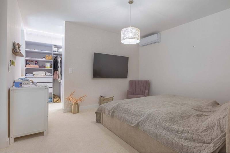 NA PREDAJ 4 IZB RD S DVOJGARÁŽOU, DUNAJSKÁ STREDA - Spálňa v rodinnom dome s televízorom, otvorenou skriňou a pohodlným kreslom.