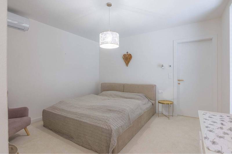 NA PREDAJ 4 IZB RD S DVOJGARÁŽOU, DUNAJSKÁ STREDA - Spálňa s posteľou a nočným stolíkom v rodinnom dome, neutrálne farby interiéru.