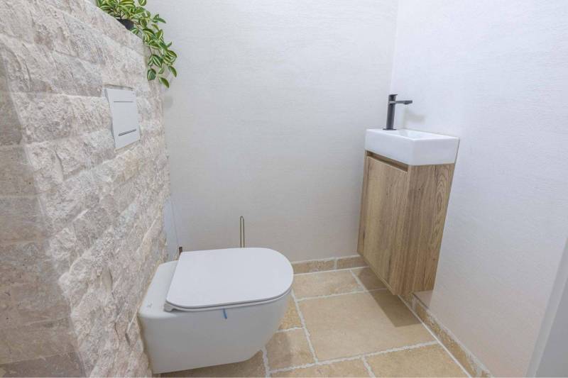 NA PREDAJ 4 IZB RD S DVOJGARÁŽOU, DUNAJSKÁ STREDA - Toaleta s kamennou stenou a malým umývadlom v rodinnom dome.