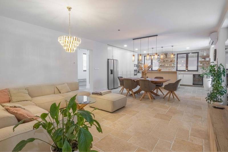 NA PREDAJ 4 IZB RD S DVOJGARÁŽOU, DUNAJSKÁ STREDA - Obývacia izba v rodinnom dome s kameňovou podlahou, veľkou sedačkou a jedálenským stolom.