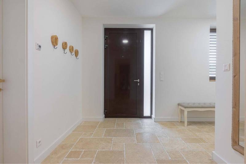 NA PREDAJ 4 IZB RD S DVOJGARÁŽOU, DUNAJSKÁ STREDA - Vstupná hala v rodinnom dome so stenovými hákmi a lavicou, podlaha s kamenným dekorom.