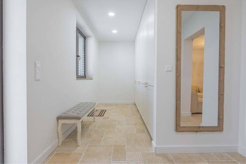 NA PREDAJ 4 IZB RD S DVOJGARÁŽOU, DUNAJSKÁ STREDA - Úzka chodba v rodinnom dome so zrkadlom, úložným priestorom a lavicou na dlažbe.