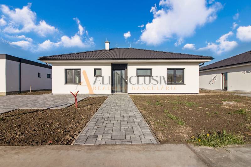 NA PREDAJ 4 IZBOVÝ RODINNÝ DOM-NOVOSTAVBA, KRÁĽOV BROD - Jednopodlažný rodinný dom s tmavou strechou a upraveným dvorom pod modrou oblohou.