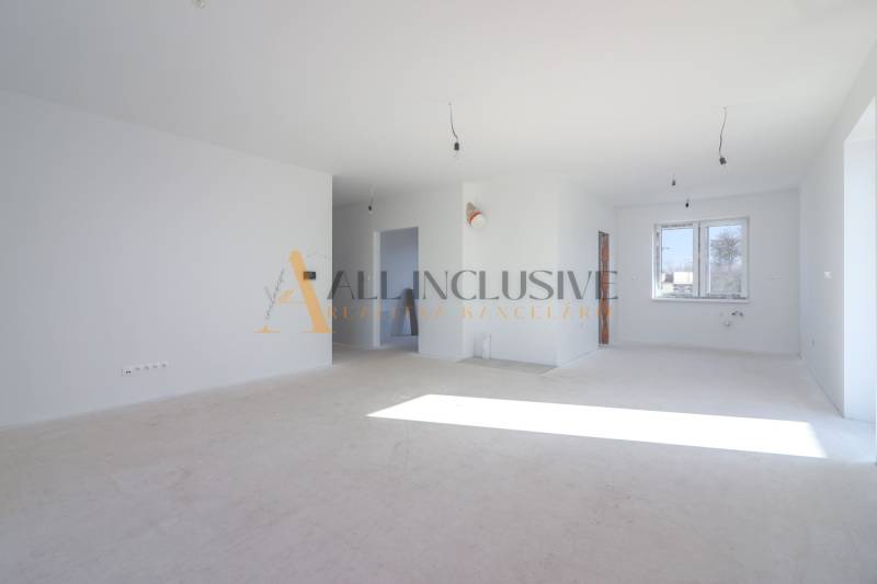 NA PREDAJ 4 IZBOVÝ RODINNÝ DOM-NOVOSTAVBA, KRÁĽOV BROD - Útulný interiér rodinného domu s prázdnou miestnosťou, bielymi stenami a slnečným osvetlením.