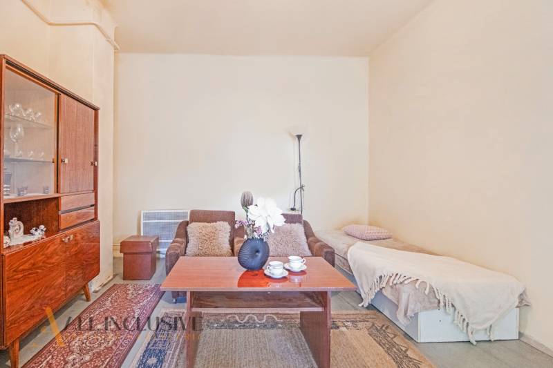 NA PREDAJ 4-IZBOVÝ RODINNÝ DOM NA PRIESTRANNOM POZEMKU - Obývačka s pohovkou, kvetmi a lampou, vytvára útulný rodinný dom.