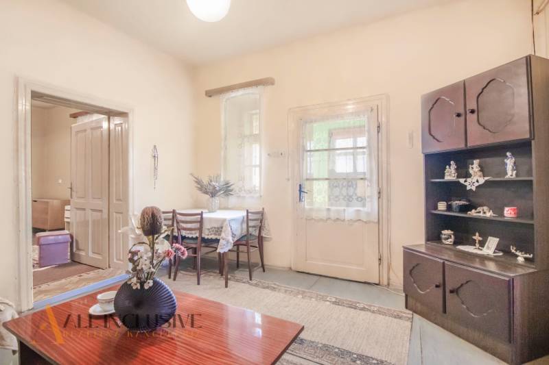 NA PREDAJ 4-IZBOVÝ RODINNÝ DOM NA PRIESTRANNOM POZEMKU - Interiér rodinného domu s drevenou nábytkom, stolom, kvetmi a dekoráciami.