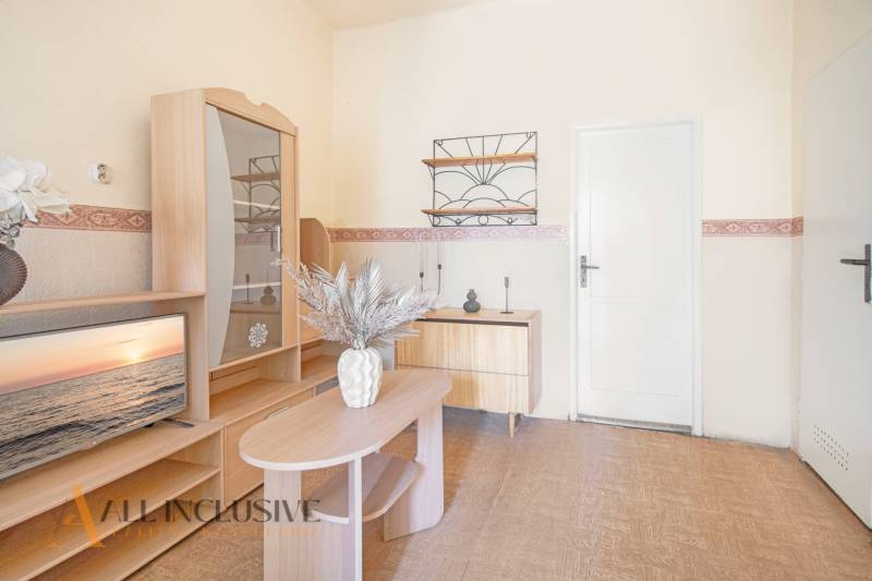 NA PREDAJ 4-IZBOVÝ RODINNÝ DOM NA PRIESTRANNOM POZEMKU - Obývacia izba s dreveným nábytkom, televízorom a dekoráciou v rodinnom dome.