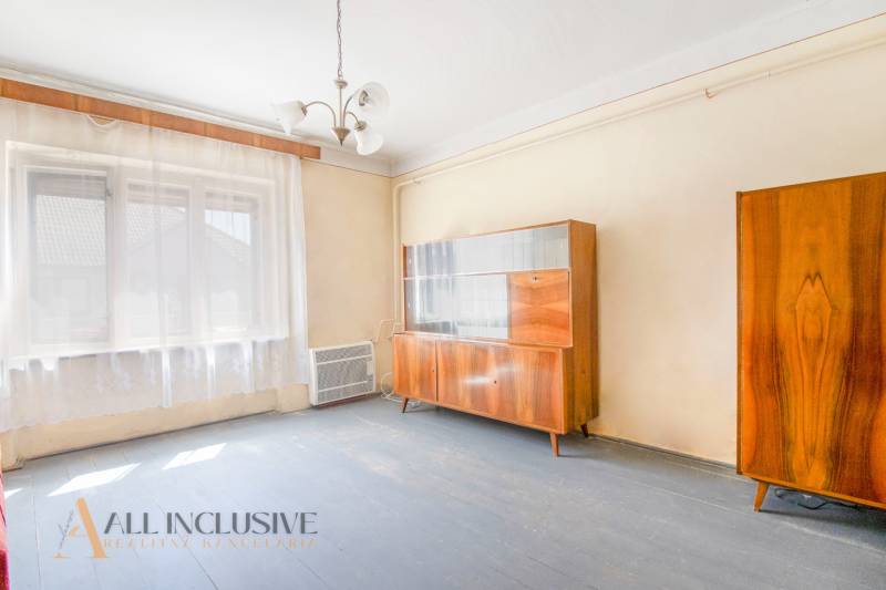 NA PREDAJ RODINNÝ DOM NA 9,5 ÁROVOM POZEMKU, OHRADY - Izba v rodinnom dome s dreveným nábytkom a veľkým oknom.