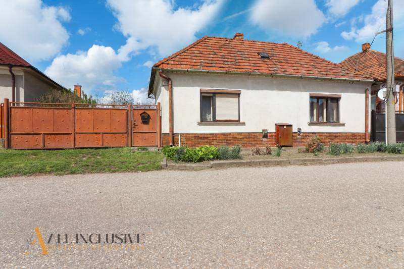 NA PREDAJ RODINNÝ DOM NA 9,5 ÁROVOM POZEMKU, OHRADY - Rodinný dom v Dunajskej Strede na ulici Ohrady s tehlovou strechou a drevenou bránou.