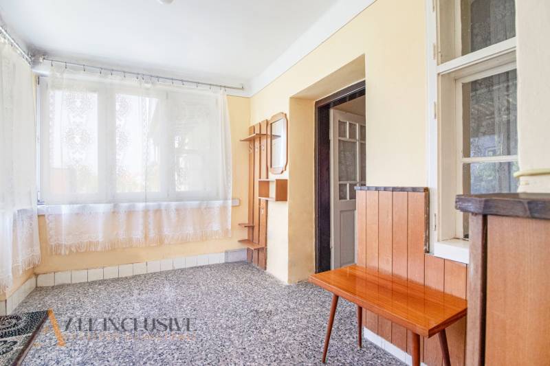 NA PREDAJ RODINNÝ DOM NA 9,5 ÁROVOM POZEMKU, OHRADY - Predsieň v rodinnom dome s mramorovou podlahou, dreveným nábytkom a závesmi.