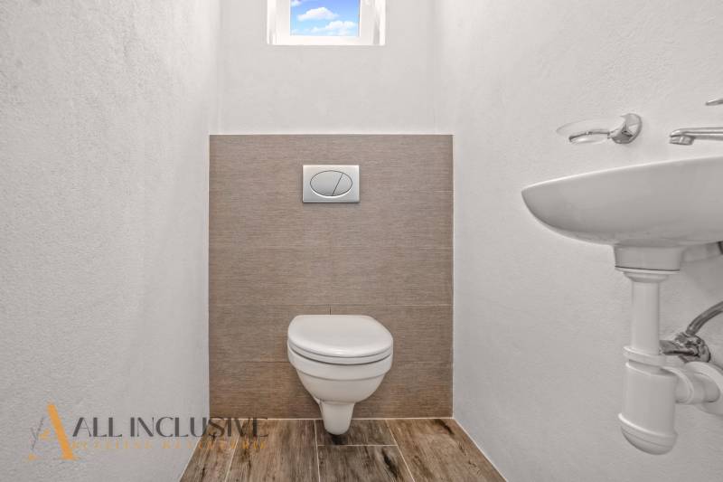 REZERVOVANÉ 3-IZBOVÝ RODINNÝ DOM V OBCI BALOŇ - Toaleta v rodinnom dome s podlahou s dreveným dekorom a malým oknom.