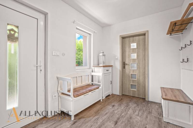 REZERVOVANÉ 3-IZBOVÝ RODINNÝ DOM V OBCI BALOŇ - Vstupná hala v rodinnom dome s bielym nábytkom a podlahou s dreveným dekorom.