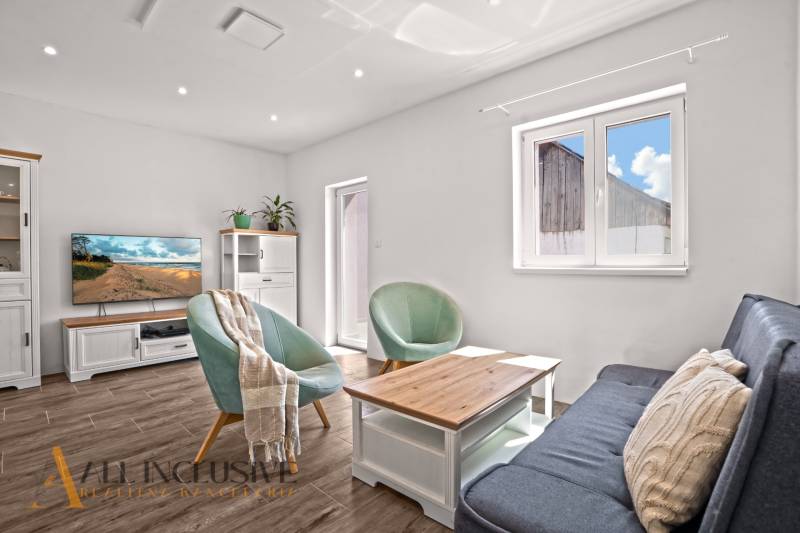 REZERVOVANÉ 3-IZBOVÝ RODINNÝ DOM V OBCI BALOŇ - Svetlá obývacia izba s podlahou s dreveným dekorom v rodinnom dome.