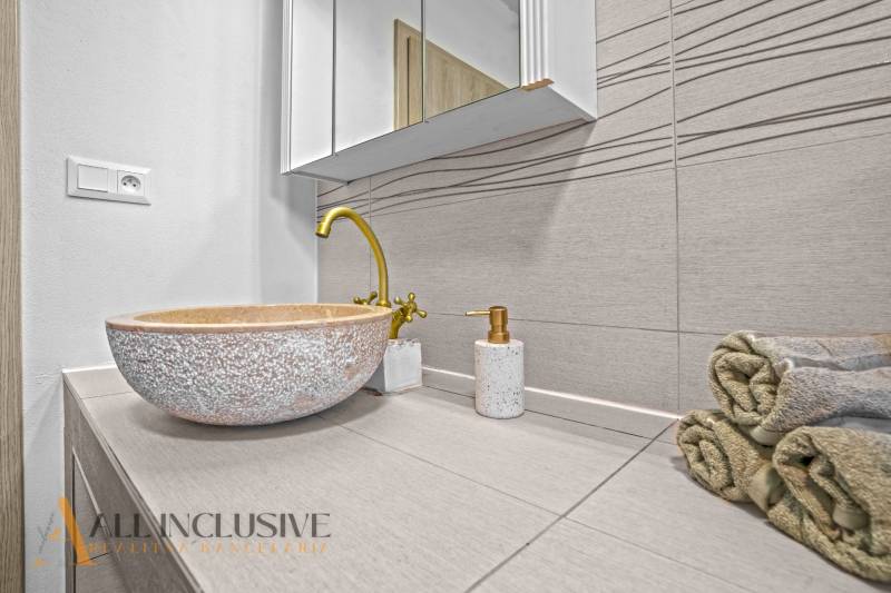 REZERVOVANÉ 3-IZBOVÝ RODINNÝ DOM V OBCI BALOŇ - Kúpeľňa v rodinnom dome s kamenným umývadlom a zlatou batériou.