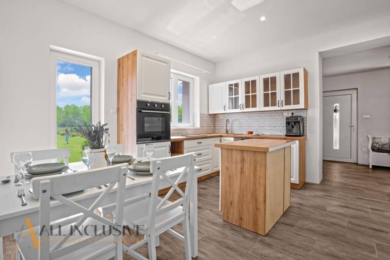 REZERVOVANÉ 3-IZBOVÝ RODINNÝ DOM V OBCI BALOŇ - Kuchyňa v rodinnom dome s dreveným dekorom a jedálenským stolom.