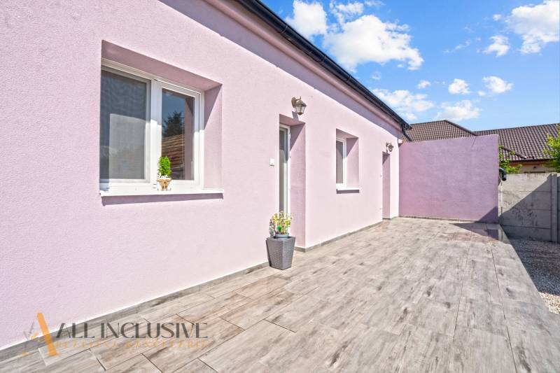 REZERVOVANÉ 3-IZBOVÝ RODINNÝ DOM V OBCI BALOŇ - Rodinný dom v Baloni s fialovou fasádou a podlahou s dreveným dekorom.