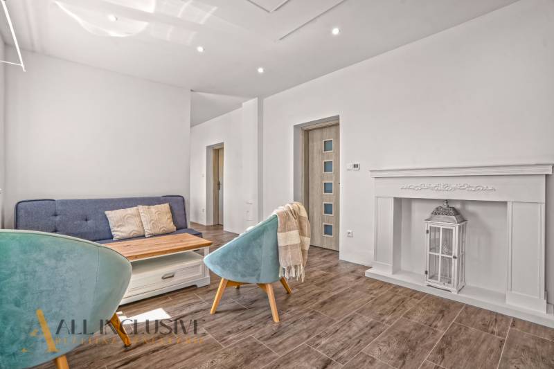 REZERVOVANÉ 3-IZBOVÝ RODINNÝ DOM V OBCI BALOŇ - Obývacia izba v rodinnom dome s pohovkou, svietidlom a podlahou s dreveným dekorom.