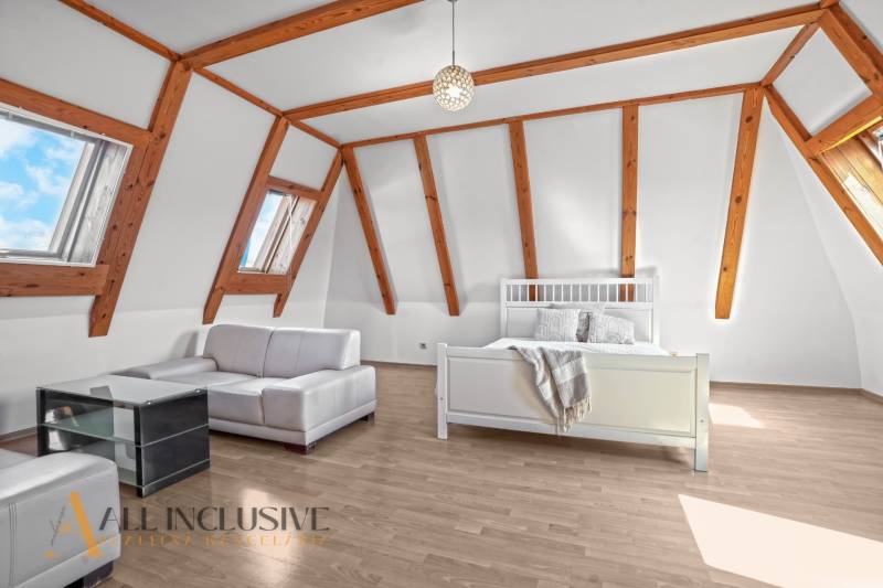 REZERVOVANÉ ZREKONŠTR. 6 IZBOVÝ RODINNÝ DOM, KOŠÚTY - Podkrovná izba v rodinnom dome s drevenými trámami, sedacou súpravou a posteľou.