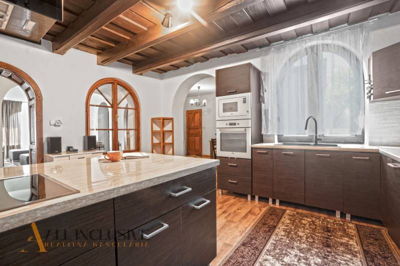 REZERVOVANÉ ZREKONŠTR. 6 IZBOVÝ RODINNÝ DOM, KOŠÚTY - Kuchyňa v rodinnom dome s podlahou s dreveným dekorom a klenutým oknom.